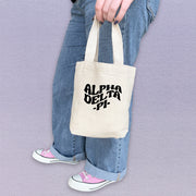 Alpha Delta Pi member showing off her ADPi mini canvas tote bag with classic Greek lettering.