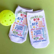A full print pattern with different funny pickleball sayings printed on white no show footie socks for men and women.