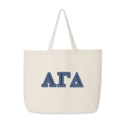Flat-lay image of Alpha Gamma Delta tote bag featuring denim Greek letters