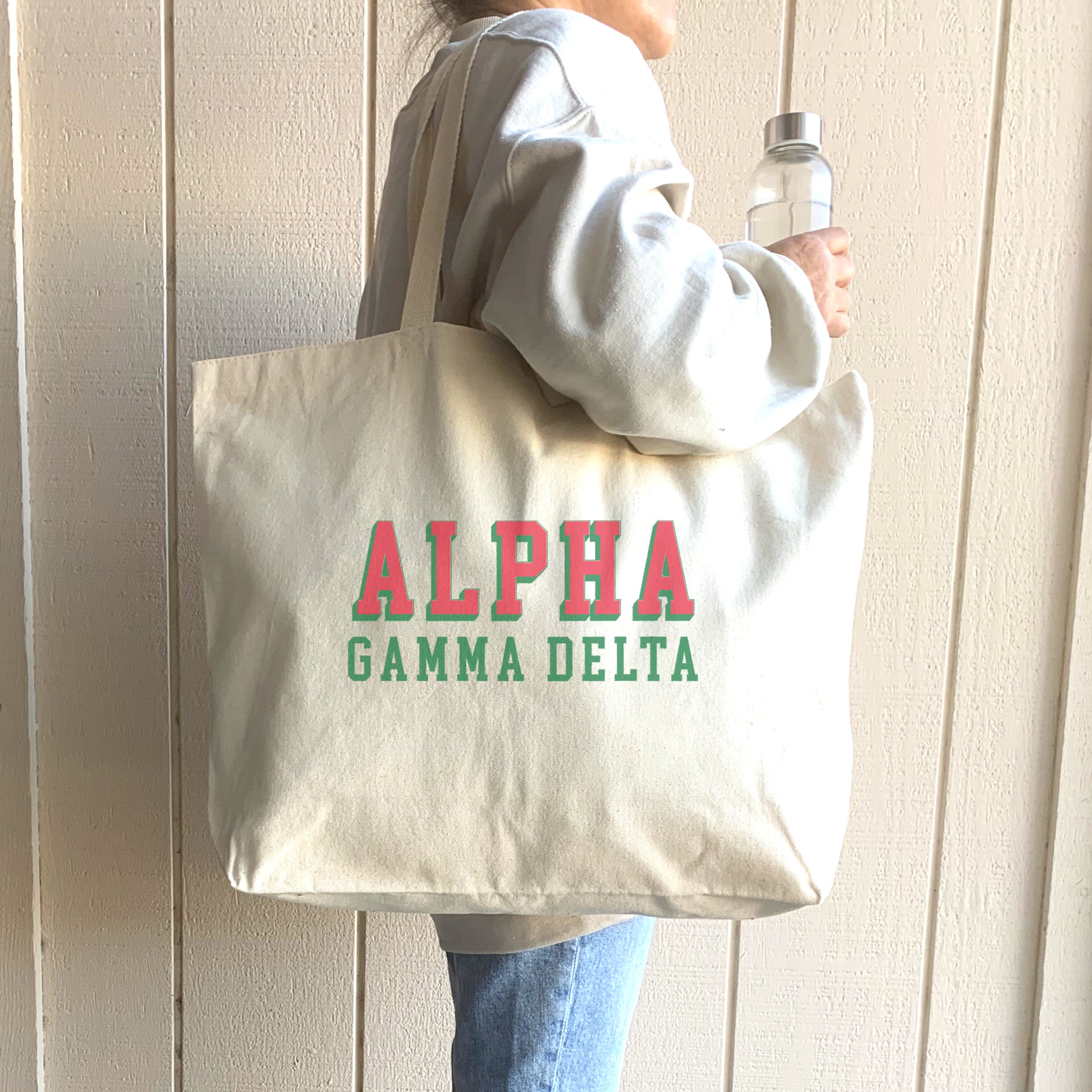 Alpha Gamma Delta member carrying a stylish tote with raised 3D Alpha Gamma Delta name design over one shoulder.