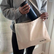 Crafted from durable canvas, each spacious bag features the Alpha Phi name digitally printed on both sides in the lower corner