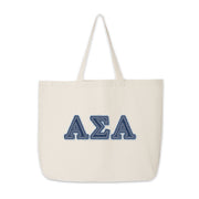 Canvas Alpha Sigma Alpha tote with denim letters displayed on a wooden surface.