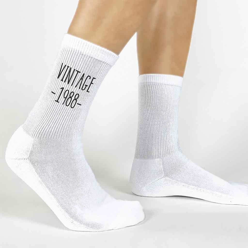 Vintage design with your birth year digitally printed on white cotton crew socks and a gift box included.