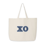 Chi Omega tote bag with denim-style letters placed flat for product display