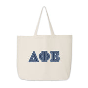 Delta Phi Epsilon tote with denim letters placed upright on a neutral background.