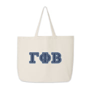 Gamma Phi Beta tote with denim letters photographed for product showcase.
