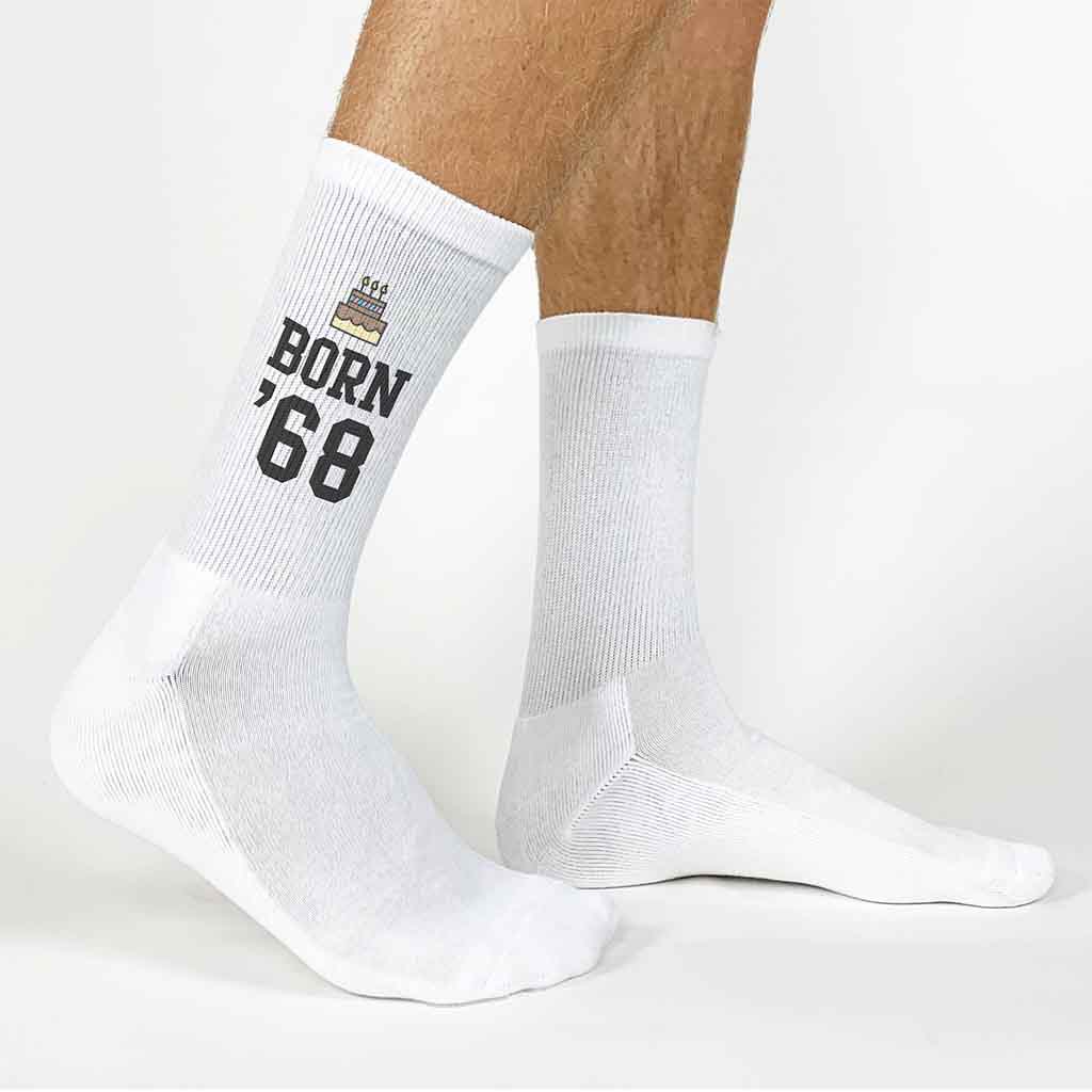 White crew socks printed with birthday cake and birth year, boxed with green ribbon