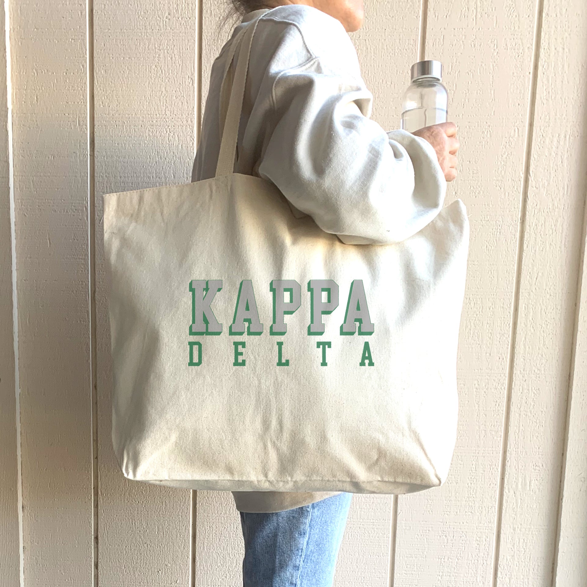 Kappa Delta sorority tote with 3D text, worn over the shoulder of a Kappa Delta member on campus.