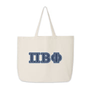 Clean shot of Pi Beta Phi denim letter tote bag standing on a flat surface.