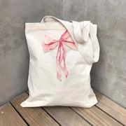 Our quality canvas tote bag printed with a large bow is a must-have medium-sized shoulder bag for every fashionista!