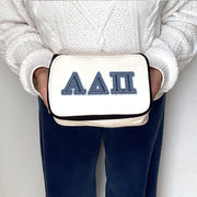 Alpha Delta Pi cosmetic bag with denim-style ADPi Greek letters, held by a sorority member
