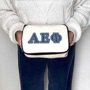 Alpha Epsilon Phi sorority member holding a canvas cosmetic bag with denim-style AEPhi letters.