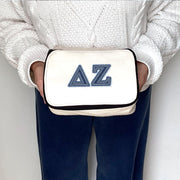 Delta Zeta cosmetic pouch with DZ denim-style letters, shown being held as part of a product image.