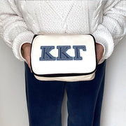 Kappa Kappa Gamma bag printed with KKG Greek letters in denim-style font, held in a styled shot.
