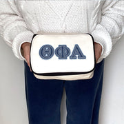 Theta Phi Alpha makeup bag shown held, featuring denim-style Theta Phi Alpha Greek letters.