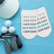 Funny I Hate Golf socks flat lay on a blue wood background.