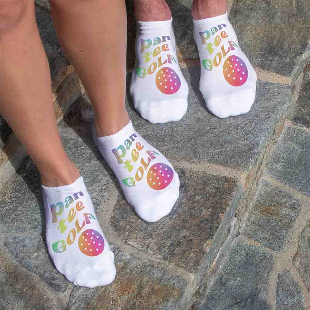 Soft comfortable white cotton no show socks digitally printed with par tee golf rainbow design are the perfect accessory for tee time.