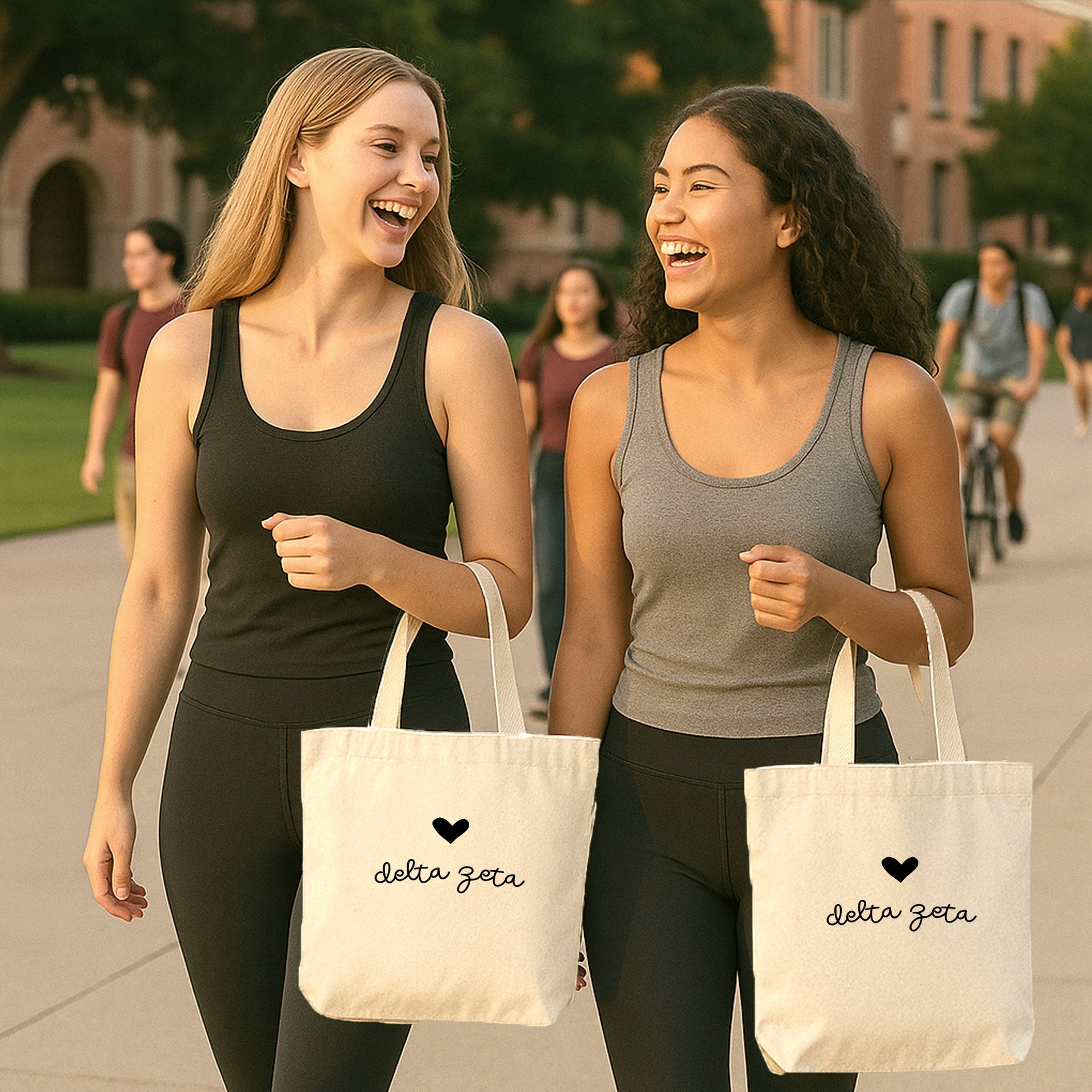 Delta Zeta tote bag with bold Greek letters and heart resting beside a member on the grass at a campus event.