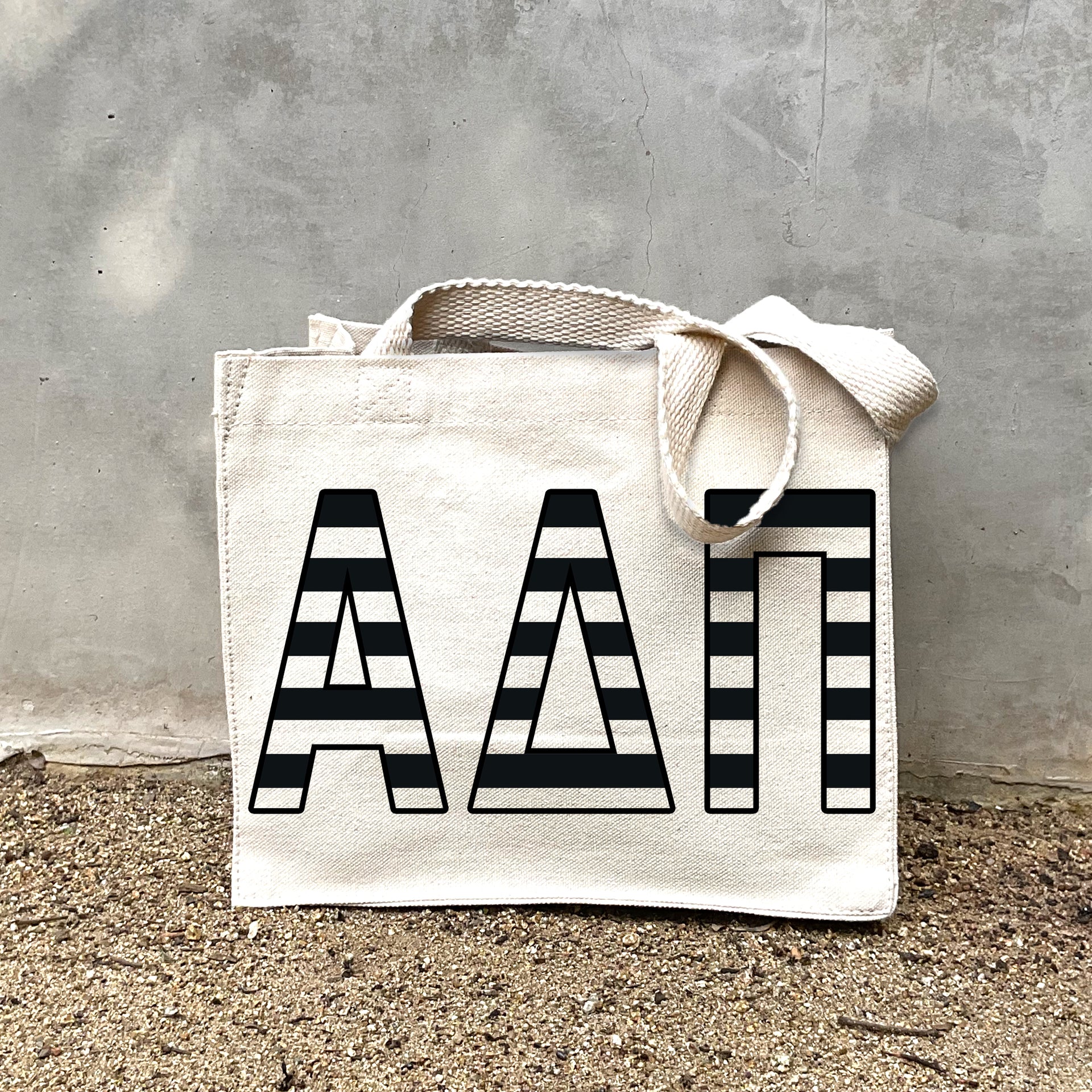 Model carrying the Alpha Delta Pi small black and white stripe tote.