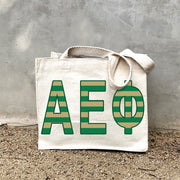 Model carrying the Alpha Epsilon Phi Greek letters in sorority colors small striped tote.