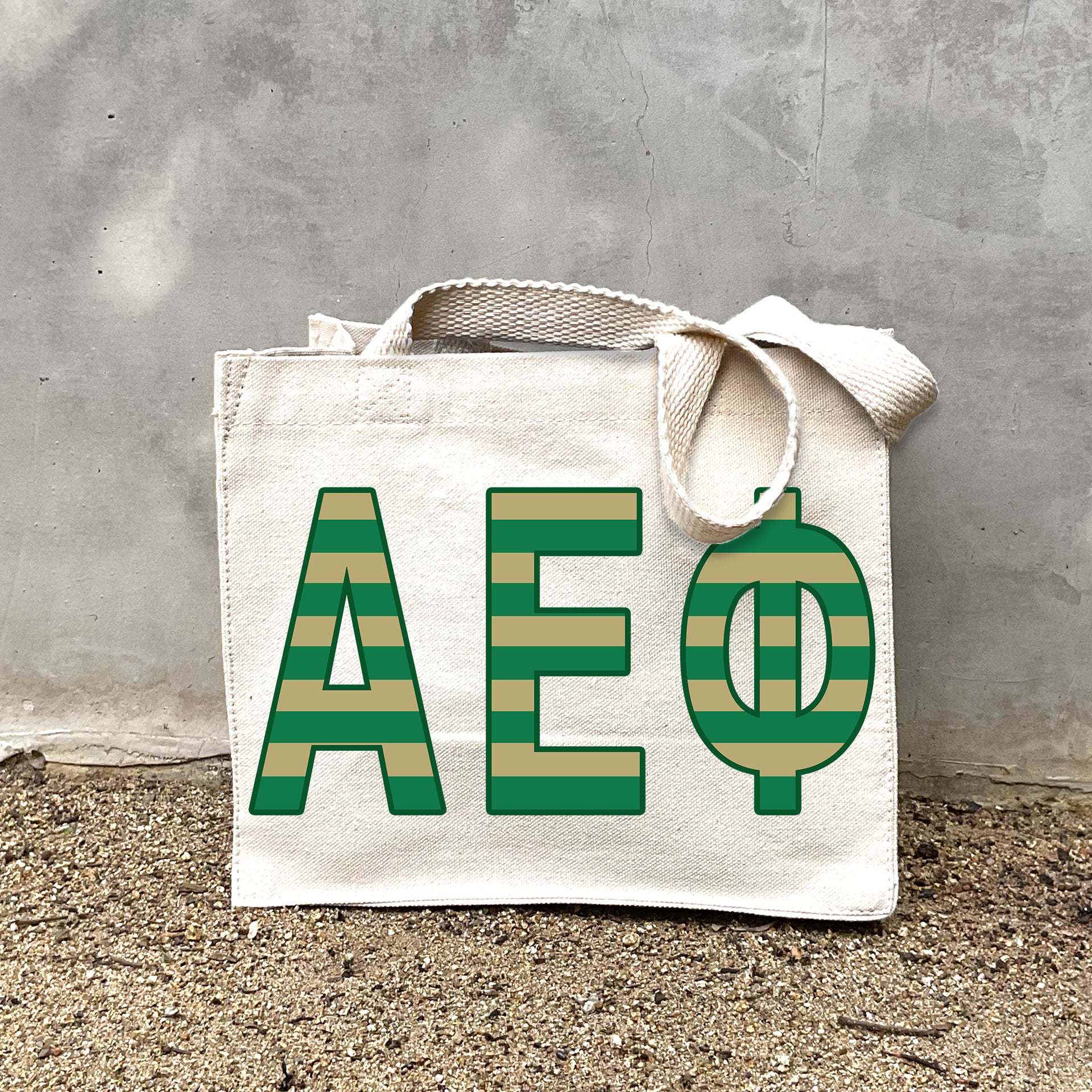 Model carrying the Alpha Epsilon Phi Greek letters in sorority colors small striped tote.