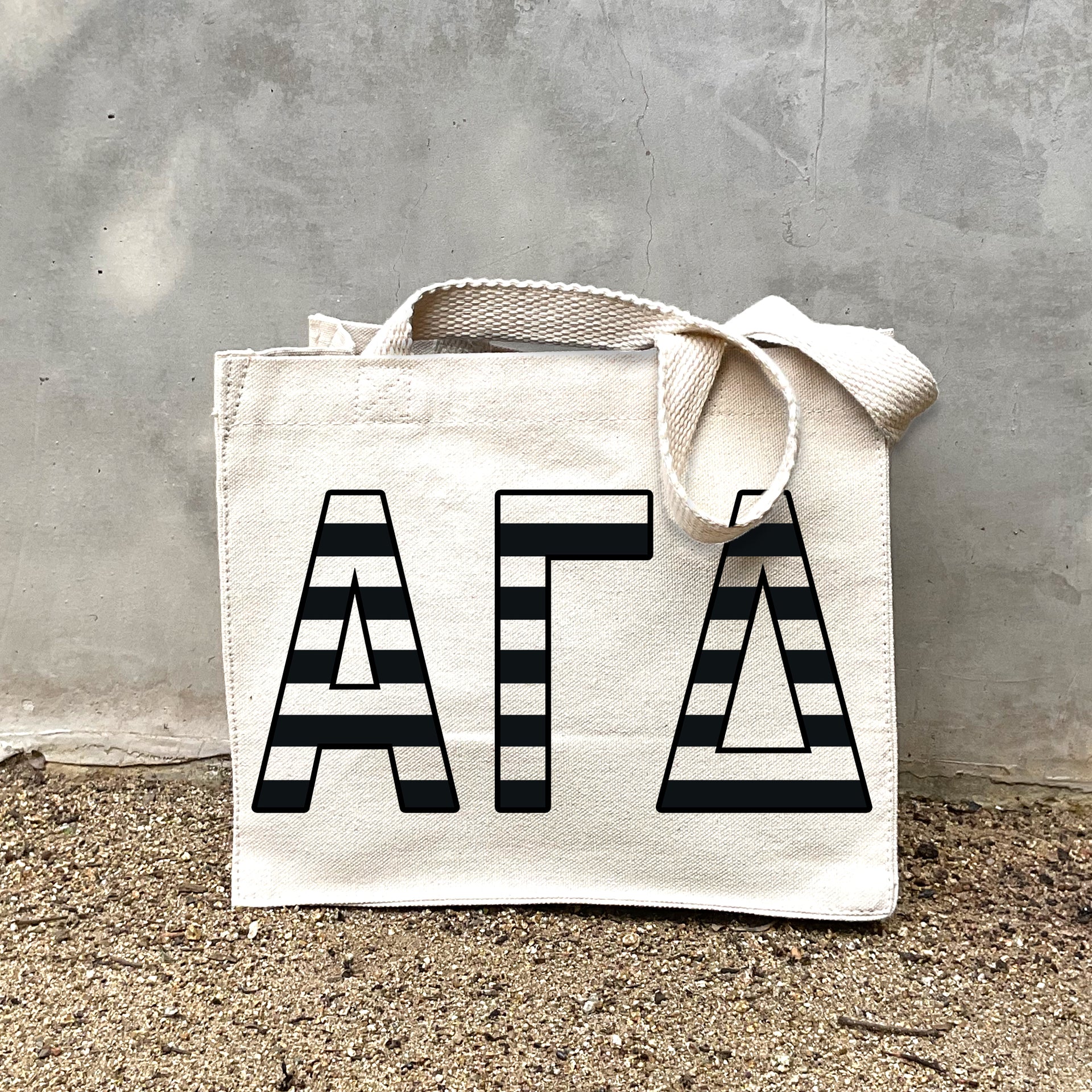 AGD Black Stripe Tote in front of a gray wall