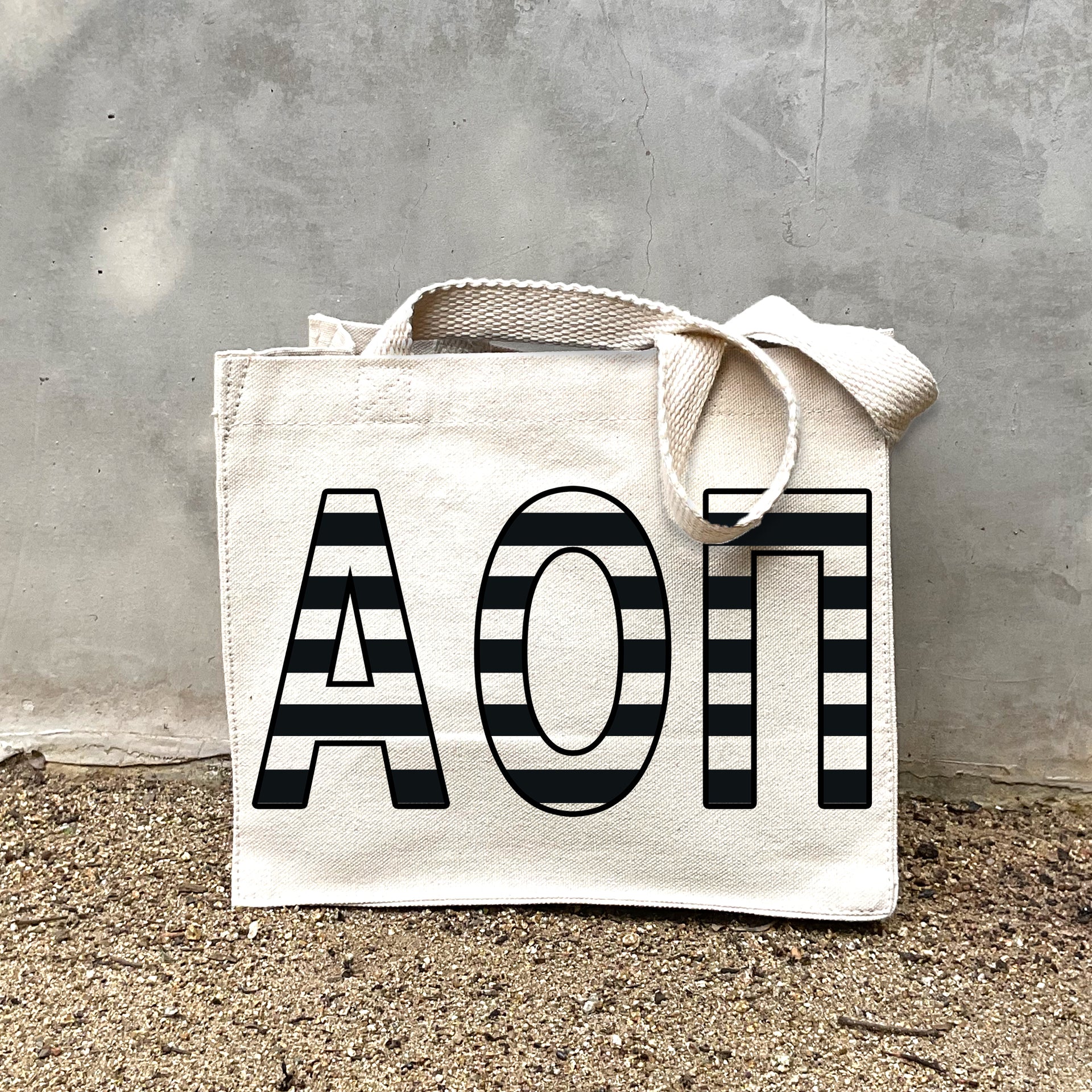 Model carrying the Alpha Omicron Pi small black and white stripe tote.
