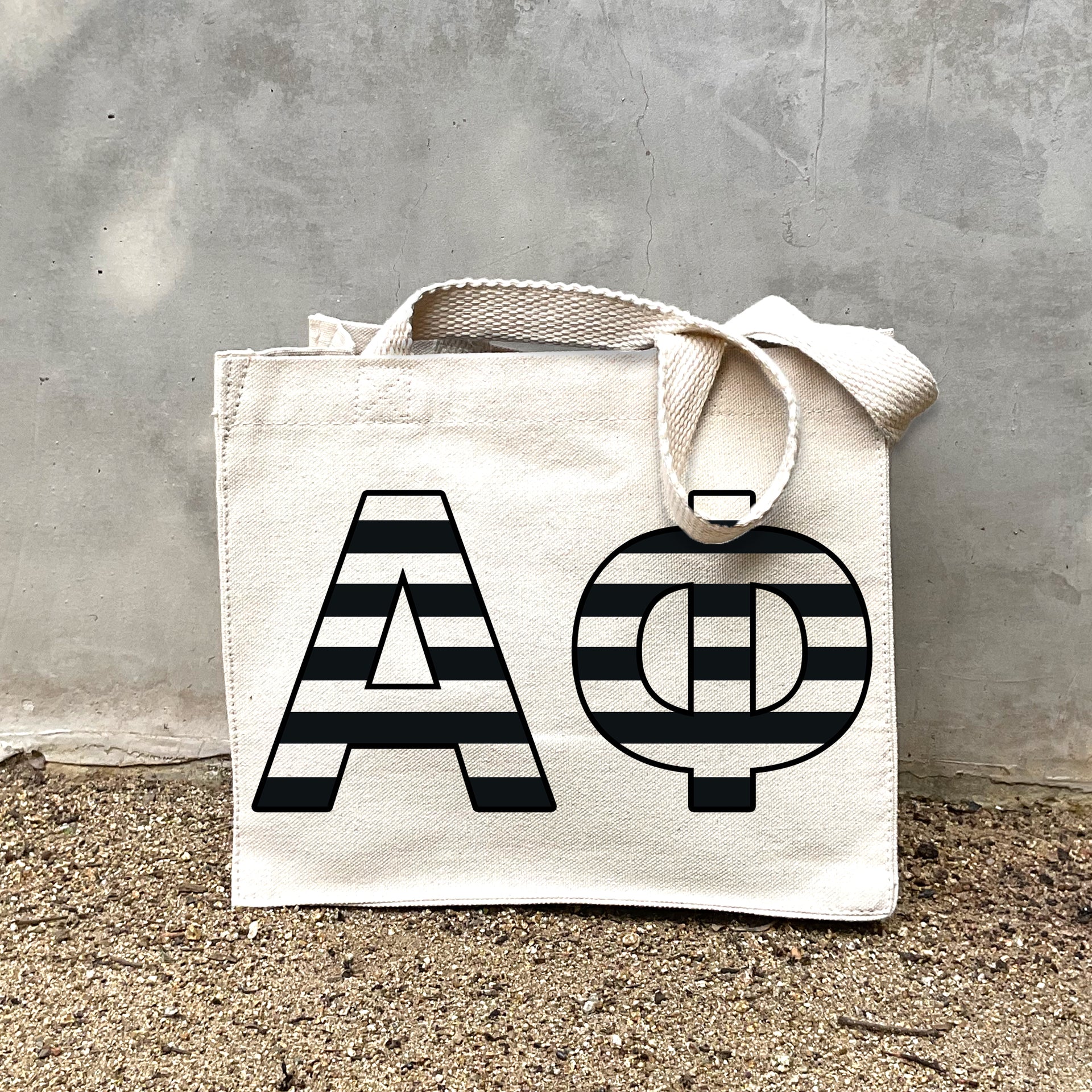 AP Black Stripe Tote in front of a gray wall