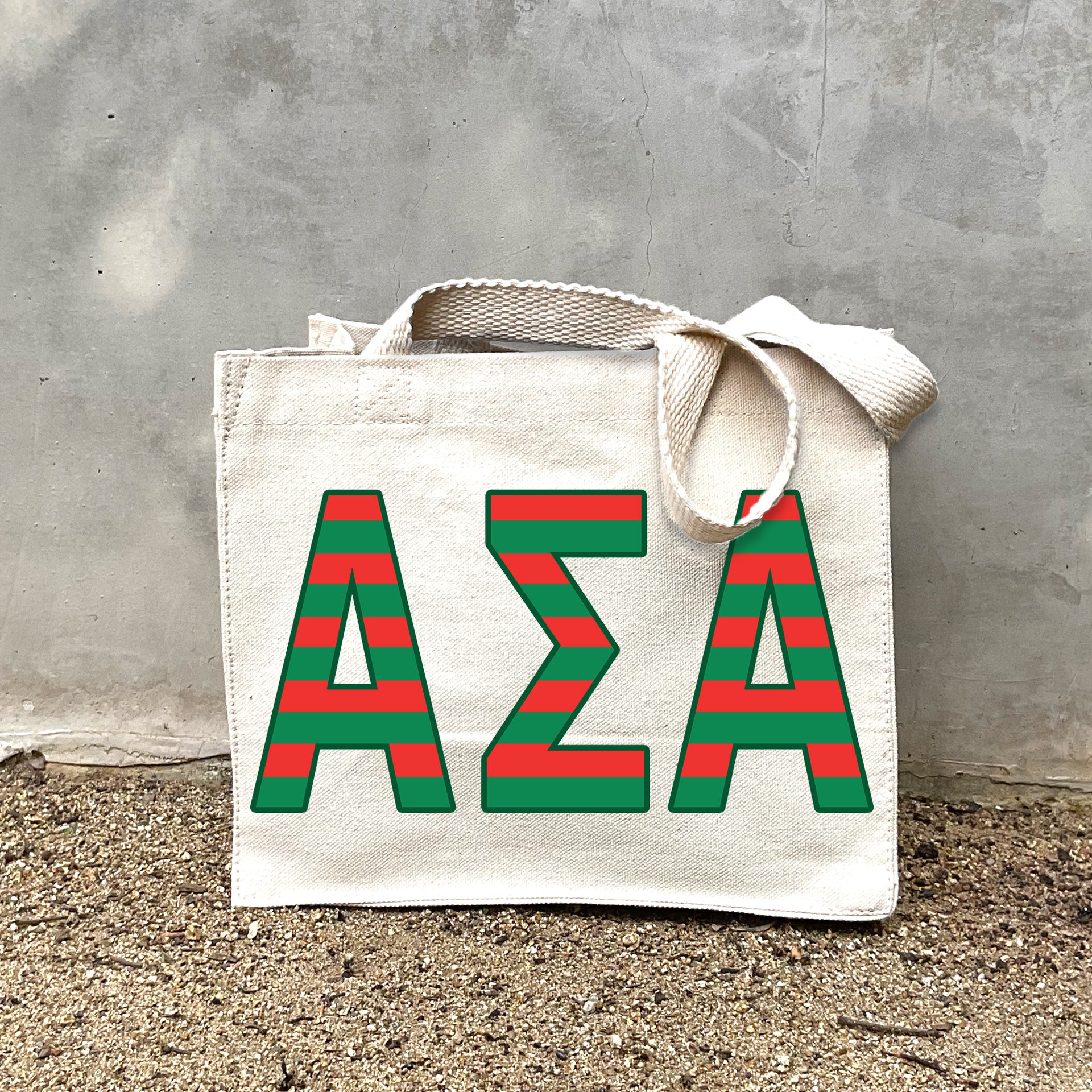 Model carrying the Alpha Sigma Alpha Greek letters in sorority colors small striped tote.