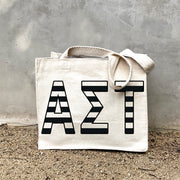 Model carrying the Alpha Sigma Tau small black and white stripe tote.