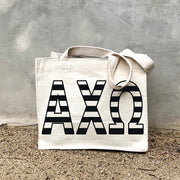 AXO Black Stripe Tote in front of a gray wall