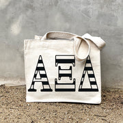 AXiD Black Stripe Tote in front of a gray wall