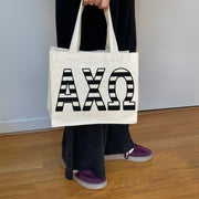 Model carrying the Alpha Chi Omega small black and white stripe tote.