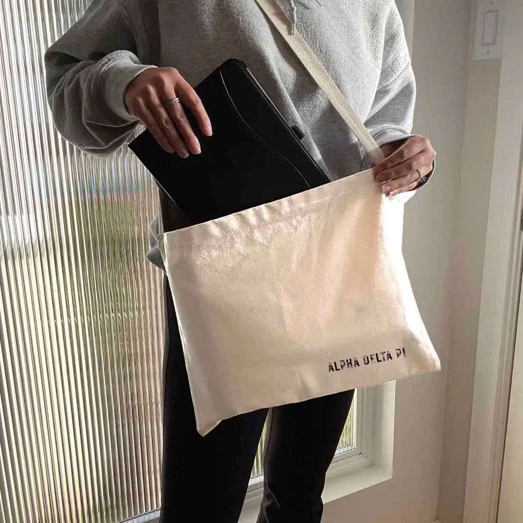 The ultimate Alpha Delta Pi messenger bag tote with a convenient crossbody strap! Crafted from durable canvas, each spacious bag features the Alpha Delta Pi name digitally printed on both sides in the lower corner.