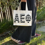 Model carrying the Alpha Epsilon Phi small black and white stripe tote.