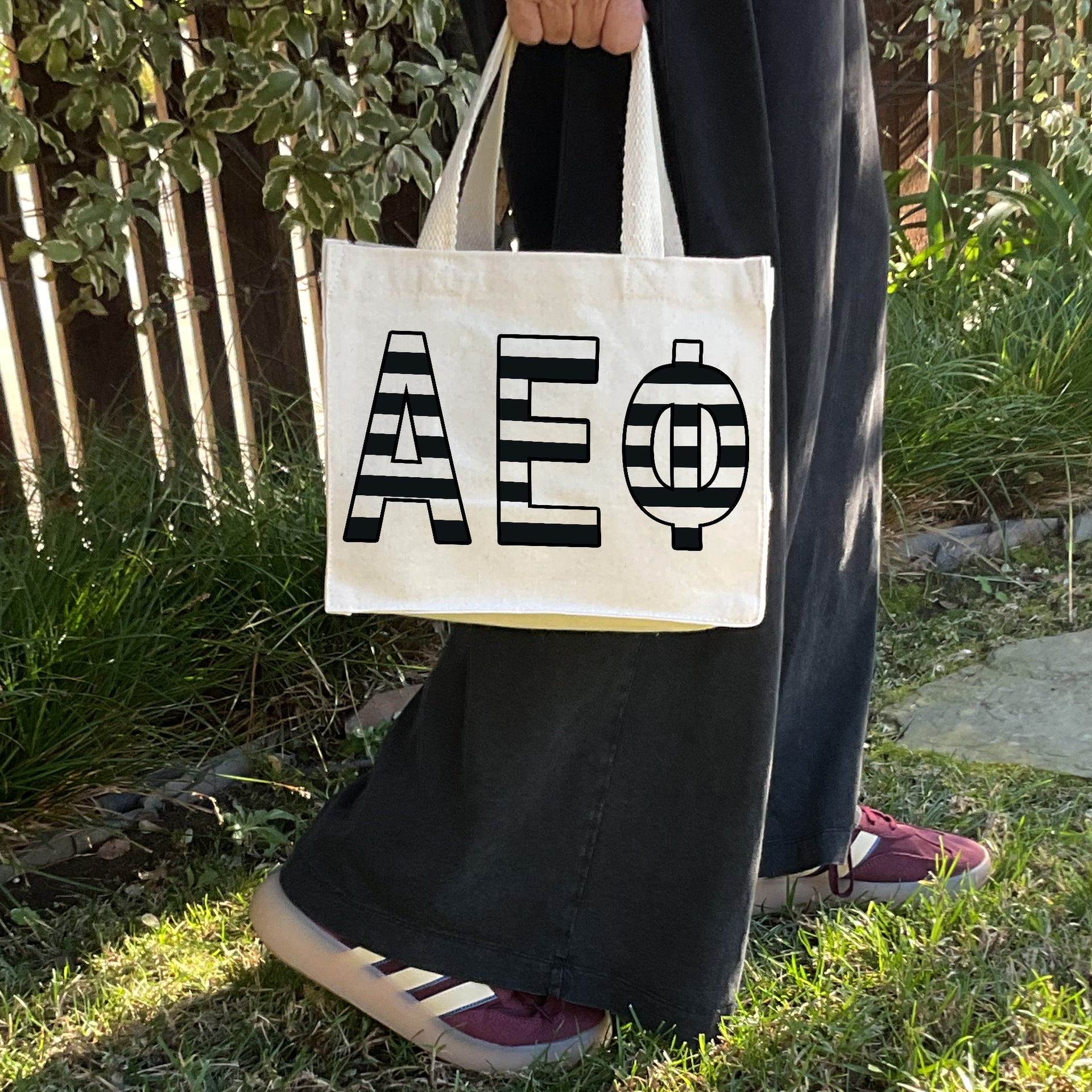 Model carrying the Alpha Epsilon Phi small black and white stripe tote.