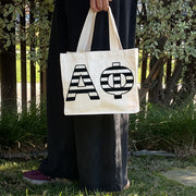 Model carrying the Alpha Phi small black and white stripe tote.