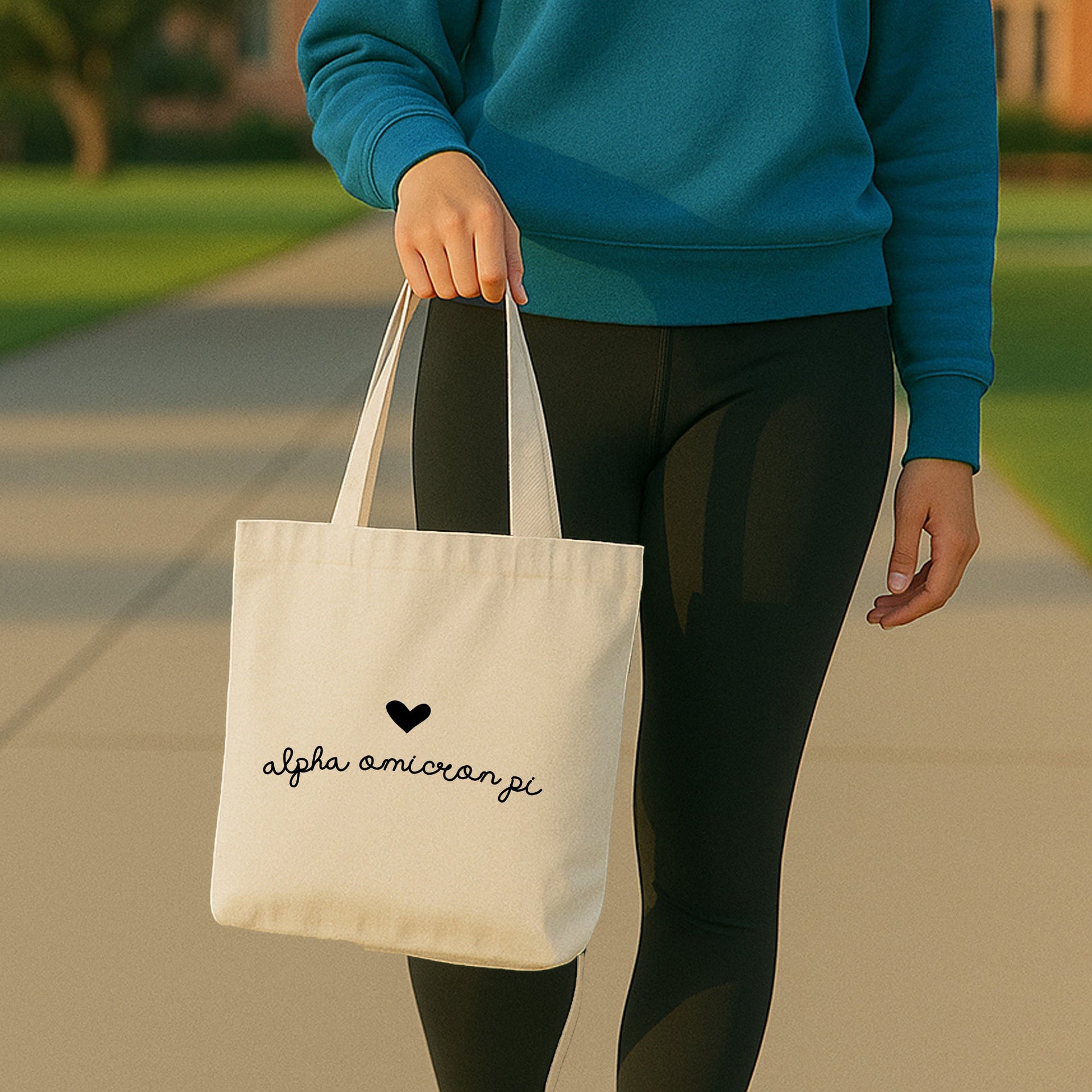 Alpha Omicron Pi tote with heart and AOII Greek letters resting on a bench during a recruitment event.