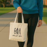 Theta Phi Alpha member holding a tote at a sisterhood social, printed with Theta Phi Alpha’s official sorority design.