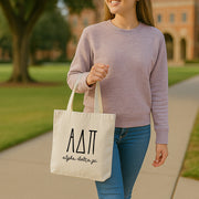 College student carrying an Alpha Delta Pi small canvas tote bag with striped Greek letters