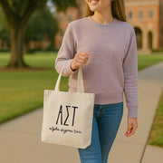 Alpha Sigma Tau student heading to class with her sorority tote in hand, featuring the AST letters and name.