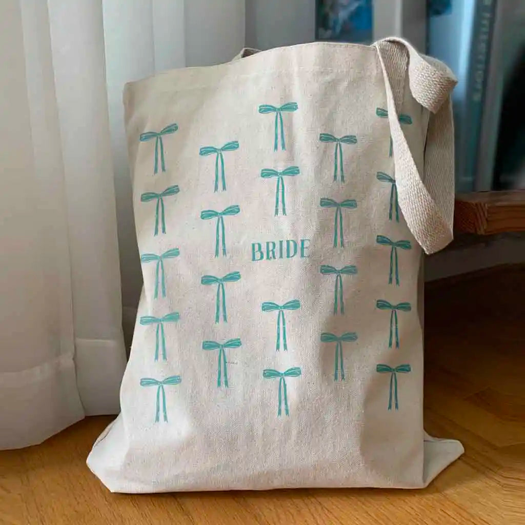 Celebrate in style with our bridal party tote bag, featuring a step and repeat pattern of a coquette bow in your choice of 6 fashion colors. 