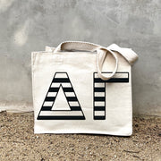 DG Black Stripe Tote in front of a gray wall