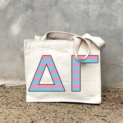 Model carrying the Delta Gamma Greek letters in sorority colors small striped tote.