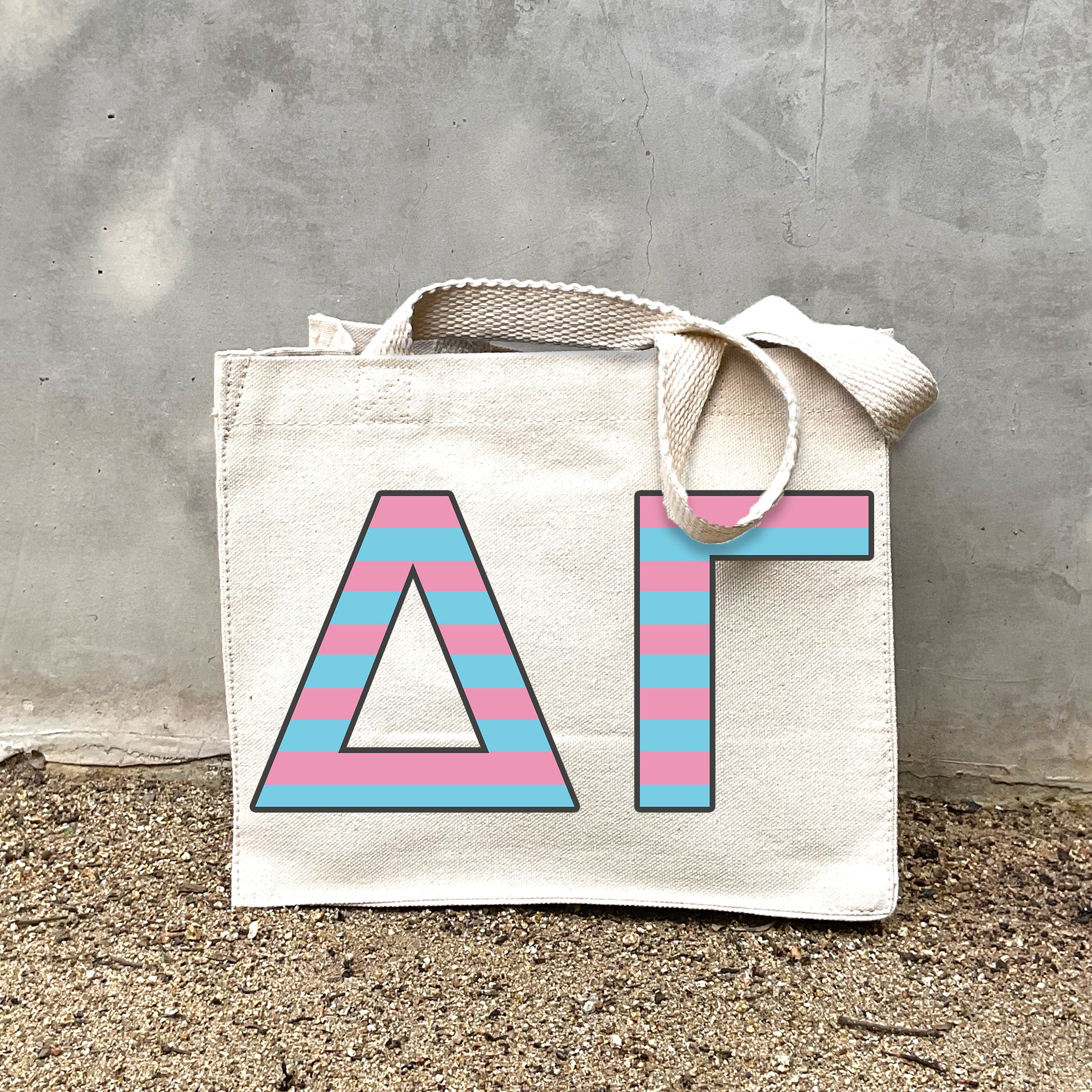 Model carrying the Delta Gamma Greek letters in sorority colors small striped tote.