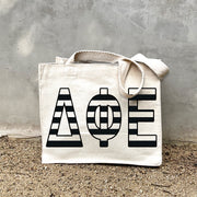 DPE Black Stripe Tote in front of a gray wall