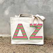 Model carrying the Delta Zeta Greek letters in sorority colors small striped tote.
