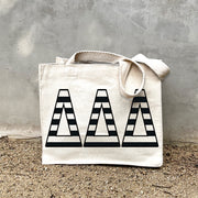 Model carrying the Delta Delta Delta small black and white stripe tote.