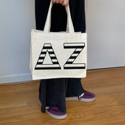 Model carrying the Delta Zeta small black and white stripe tote.