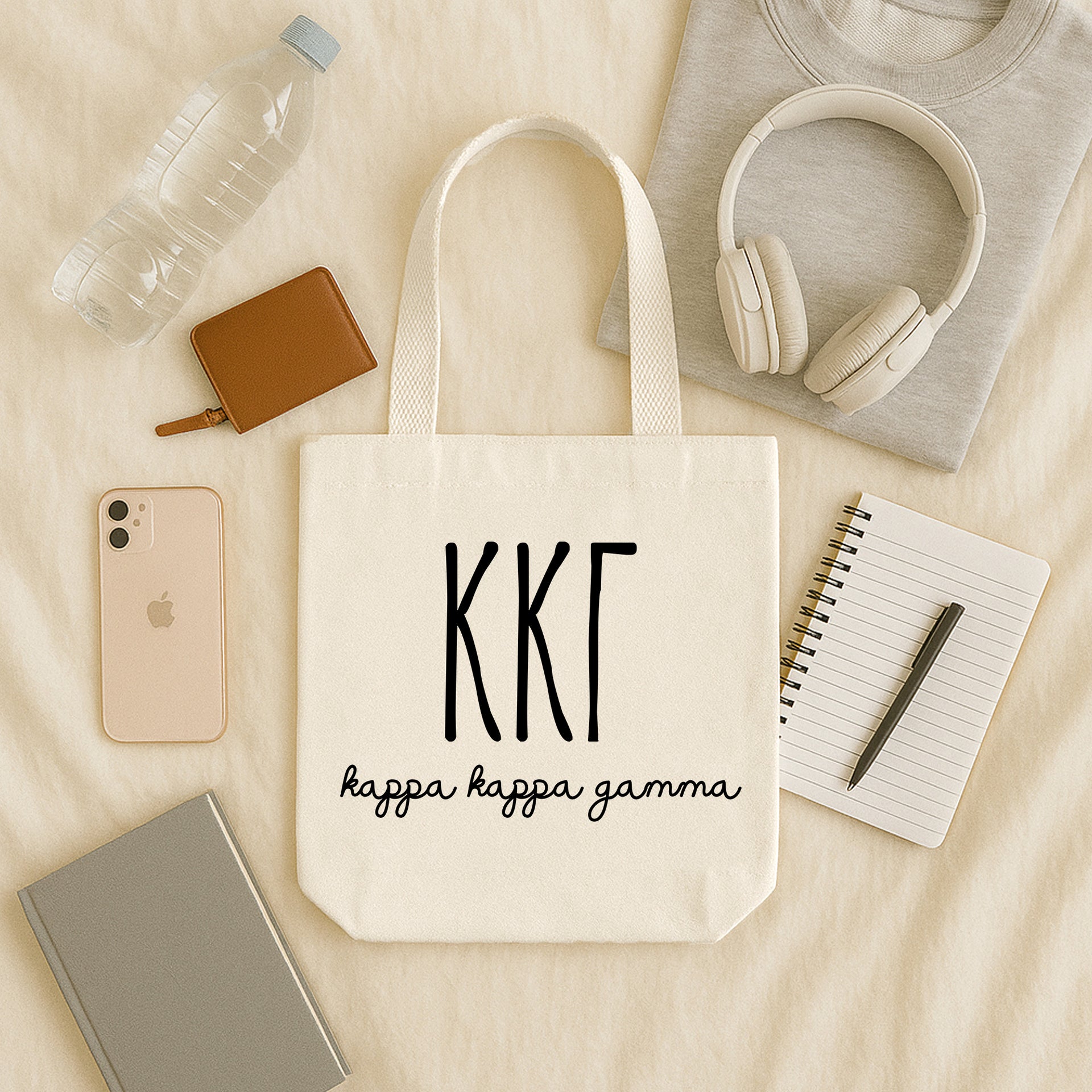 Kappa Kappa Gamma small canvas tote bag with striped Greek letters styled in a flat lay with everyday essentials